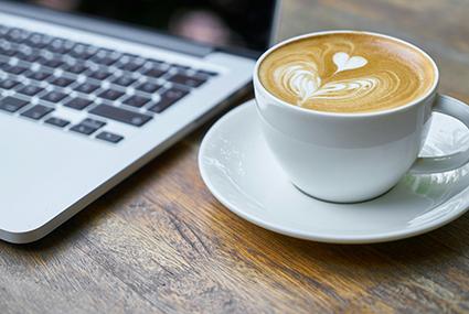 Coffee and a laptop on a table